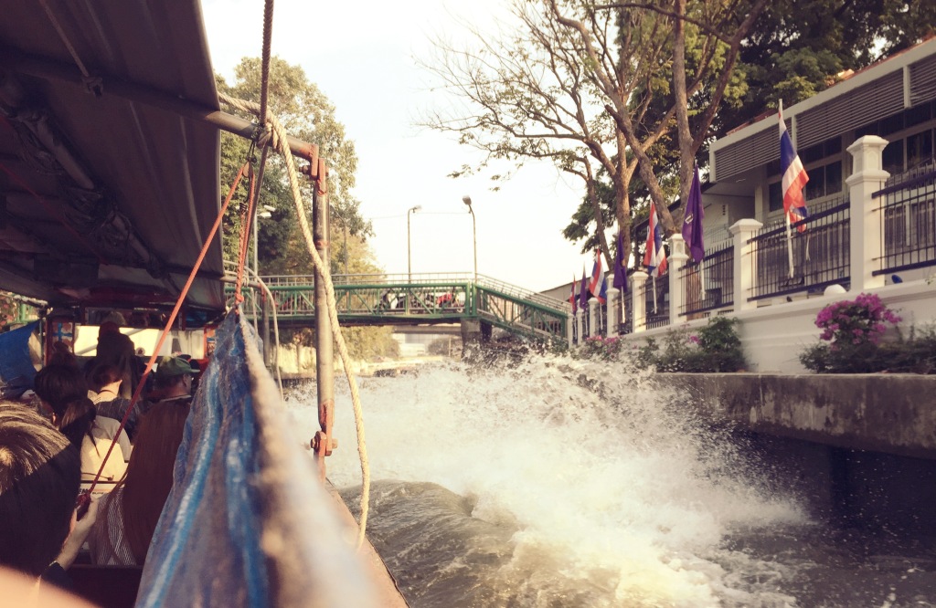 The narrow canal becomes a strait of raging waves as the passenger boats pass by.